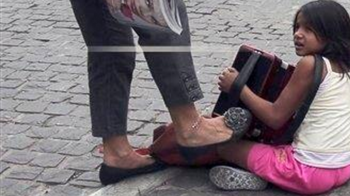 Φωτό-σοκ: Γυναίκα κλωτσάει κοριτσάκι που παίζει ακορντεόν κάτω από την Ακρόπολη